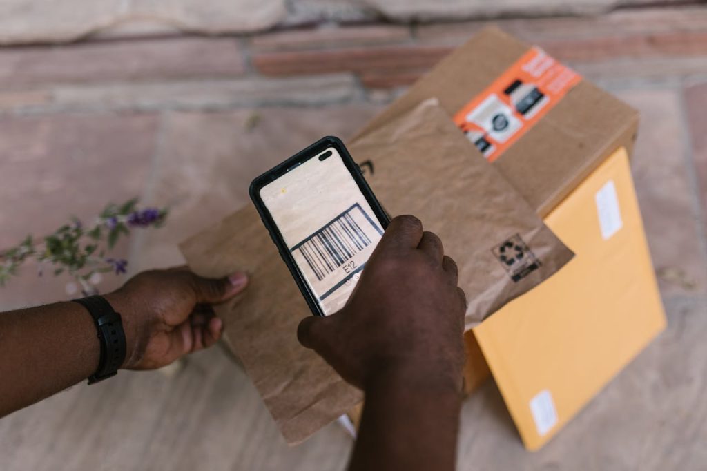 A person scans package barcodes using a smartphone for delivery logistics.